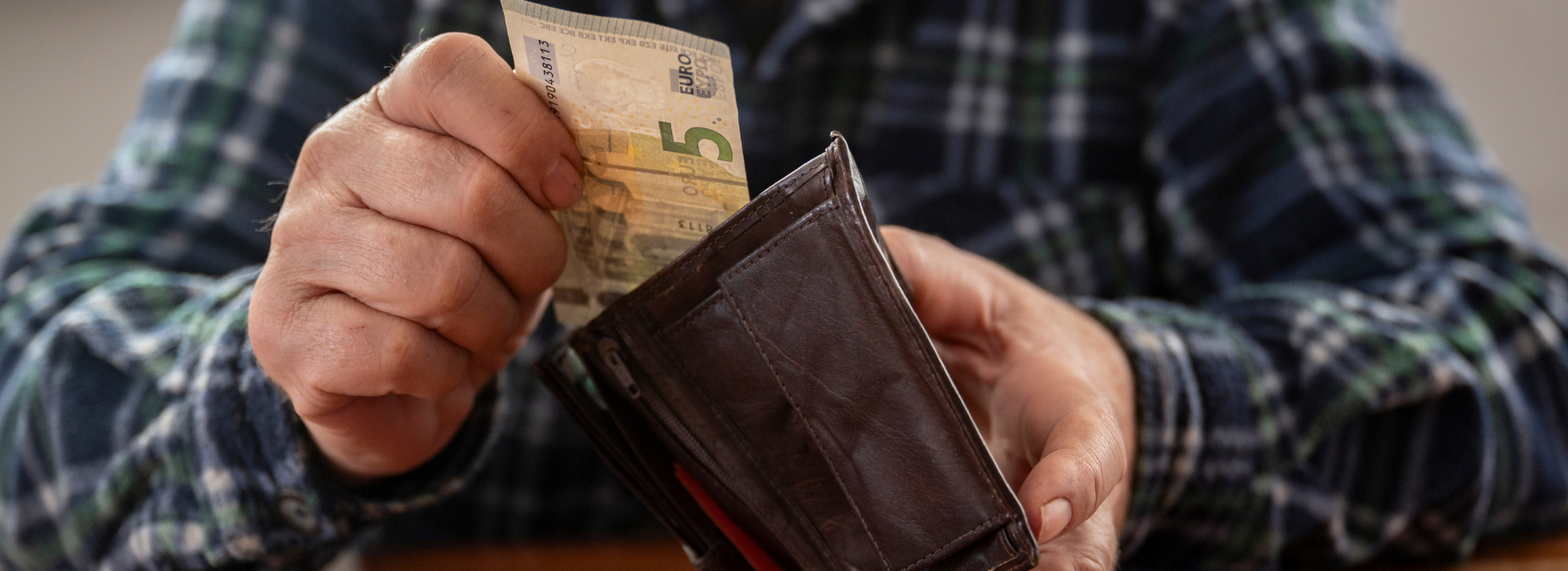 Senior vyberajúci peniaze z peňaženky – rodičovský dôchodok 2026 a finančná pomoc pre rodičov